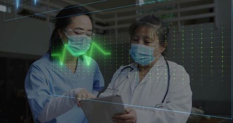 Clinicians reviewing tablet with holographic ECG and collaborating on patient vitals