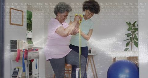 Physiotherapist Guides Senior Rehabilitation with Resistance Band