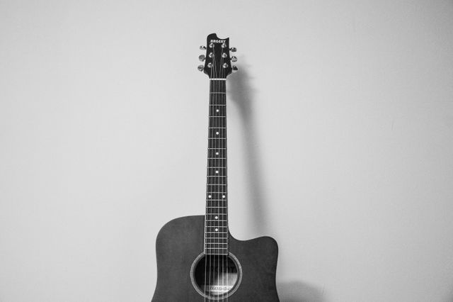 Perfect for use in music-related content, advertisements, blogs about music practice, interior decoration tips, and minimalist lifestyle articles. Could also fit well in education materials related to learning music or playing guitar.