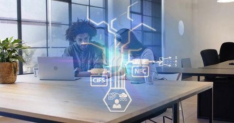 Coworkers collaborating over laptop with augmented tech icons in modern office