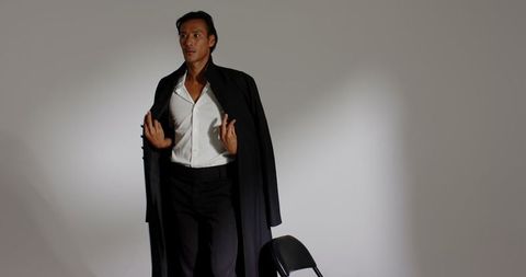 Elegant man in black overcoat in studio setting