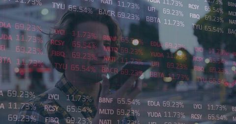 Young man speaking into smartphone amid stock ticker overlay at urban dusk