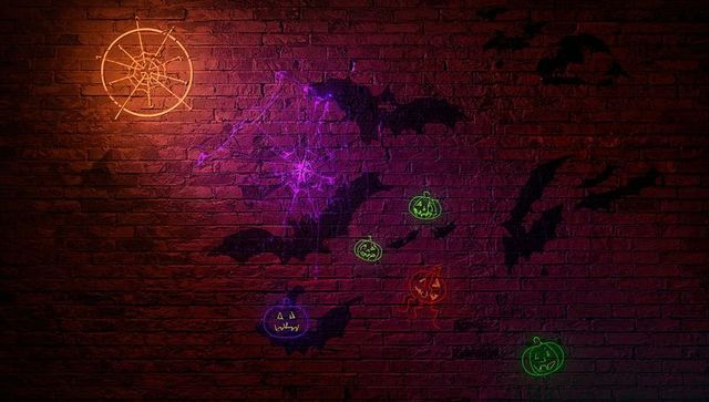 Glowing neon halloween decorations on brick wall