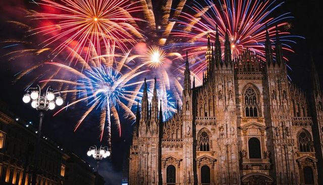 Fireworks exploding over gothic cathedral spires nighttime celebration in historic piazza