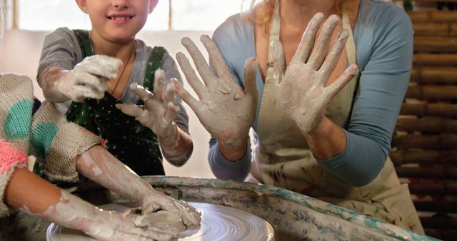 Smiling Woman and Child Learning Pottery Together with Muddy Hands - Download Free Stock Images Pikwizard.com