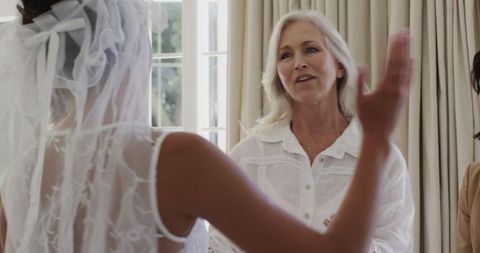Bride Getting Ready with Family for Wedding Ceremony Indoors