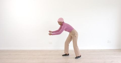 Trendy individual dancing energetically in minimalist space