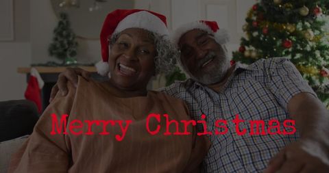 Happy Senior Couple Celebrating Christmas at Home in Santa Hats
