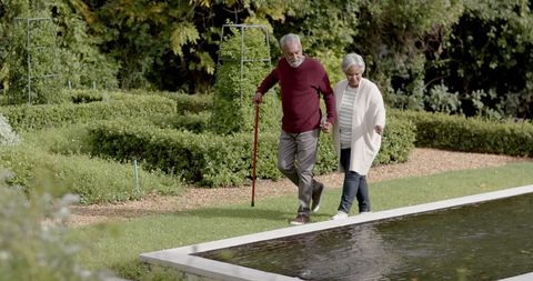 Senior Couple Walking Hand in Hand Through Serene Garden
