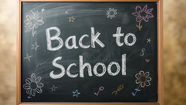 Chalkboard with back to school text and doodles in classroom