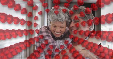 Joyful Senior Couple Embracing with Romantic Overlay at Home