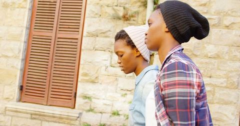 African American Twin Sisters Walking Through Urban Neighborhood