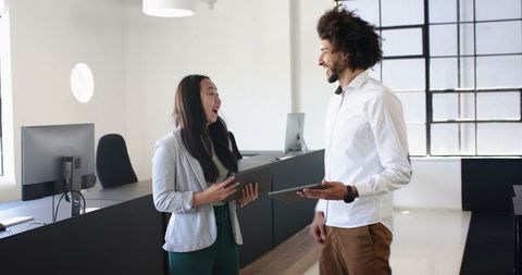 Colleagues collaborating with tablets in contemporary office space