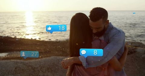 Couple embracing at sunset with digital interaction concept