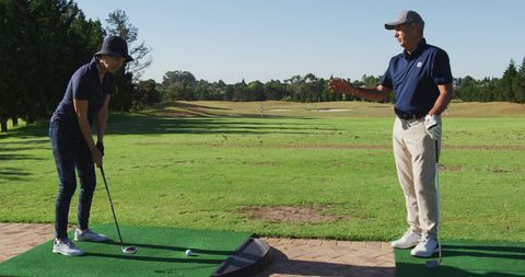 Senior Couple Enjoying Golf Coaching Session on Sunny Day