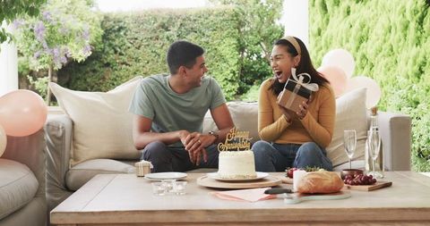 Happy Couple Celebrating with Gifts and Cake Outdoors