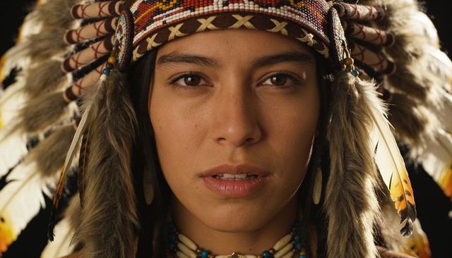 Indigenous woman wearing warbonnet closeup showcasing beadwork and ceremonial detail