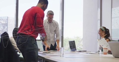Business Team Collaborating with Laptops and Charts in Modern Office