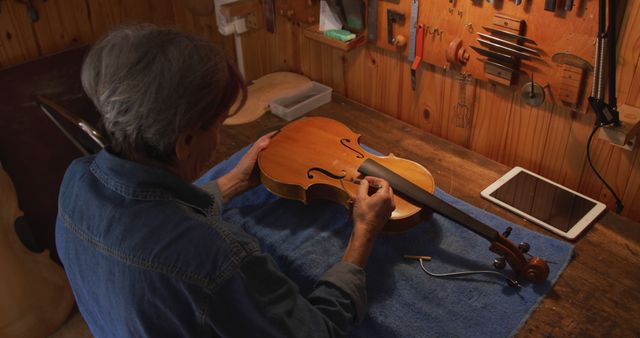 Craftsman Working Attentively on Polishing Wooden Violin in Workshop - Download Free Stock Images Pikwizard.com