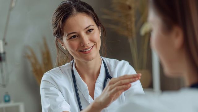 Friendly female clinician offering reassuring touch and attentive care during consultation