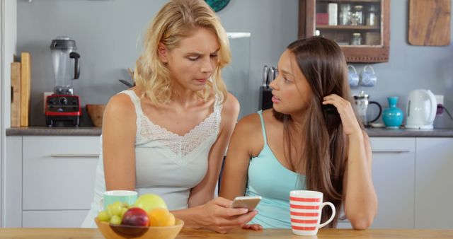 Mother and Daughter Discussing Over Smartphone in Kitchen - Download Free Stock Images Pikwizard.com