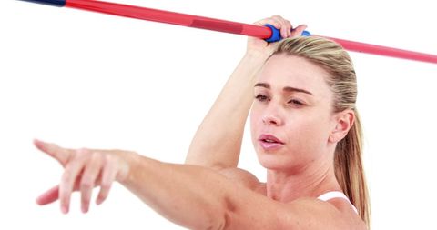 Athletic woman posing with javelin on white background