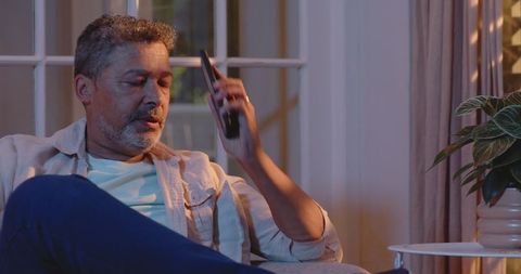 Senior man pondering at home in evening light