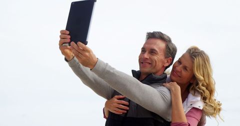Middle-Aged Couple Joyfully Taking Selfie with Tablet