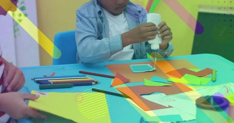 Children gluing paper crafts in colorful classroom creating collaborative art and learning