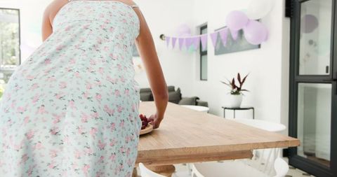 Preparing birthday party table indoors with festive decorations