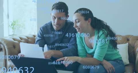 Couple Analyzing Data on Laptop with Digital Overlay