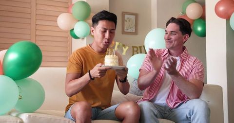 Joyful Birthday Celebration with Happy Couple on Couch Inside