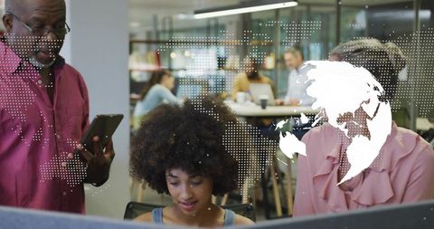 Diverse team collaborating around curved monitor with tablet and global data overlay