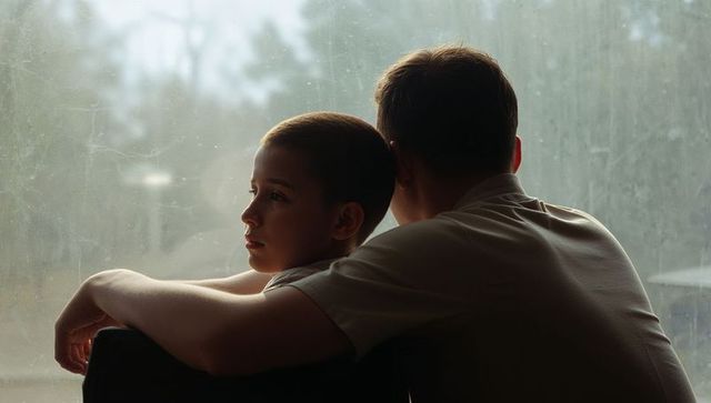 Parent and son backlit gazing through smudged window quiet bonding moment