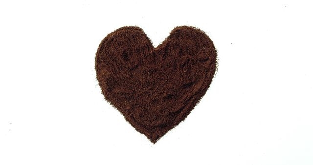 A heart shape is created from coffee grounds against a white background, with copy space. It symbolizes a love for coffee or could be used in themes related to Valentine's Day and romance.