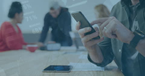 Businessman Using Smartphone in Busy Office with Data Overlay