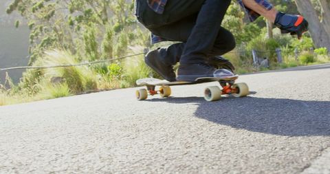Skateboarder cruising downhill in sunny outdoor adventure