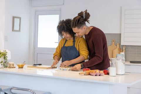 African american couple baking together at sunlit modern kitchen island