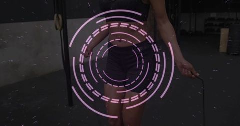 Woman jumping rope in gym swinging jump rope with neon circular overlay for cardio workout