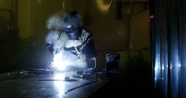 Welder in Protective Gear Welding Metal in Dark Workshop with Sparks - Download Free Stock Images Pikwizard.com