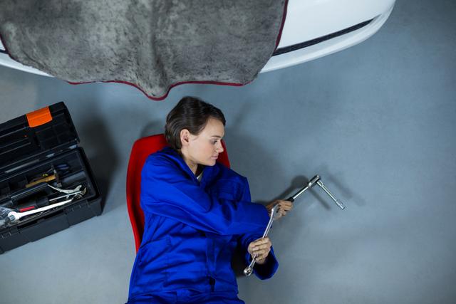 Female Mechanic Working Under Car in Garage - Download Free Stock Photos Pikwizard.com