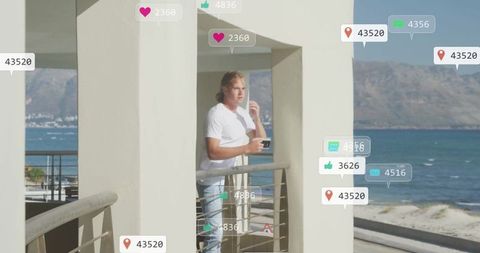 Man Engaging with Social Media Icons by Seaside
