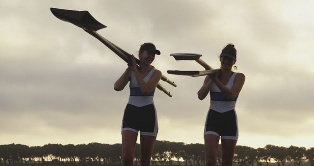 Two Female Rowers Carrying Oars at Sunset - Download Free Stock Images Pikwizard.com