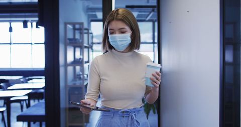 Businesswoman with Mask Working on Tablet in Modern Office