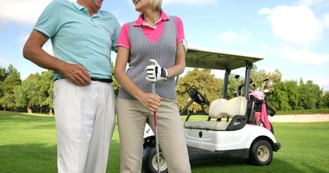 Smiling senior golfers enjoying a leisurely day on the green