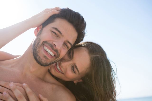 Smiling couple embracing at beach - Download Free Stock Photos Pikwizard.com