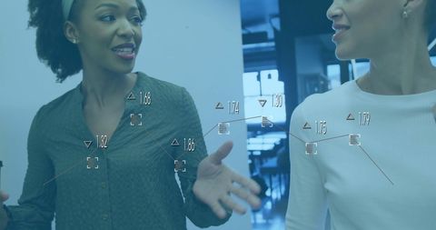 Female Colleagues Analyzing Data in Modern Office Environment