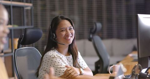 Smiling customer service representative wearing headset at workstation