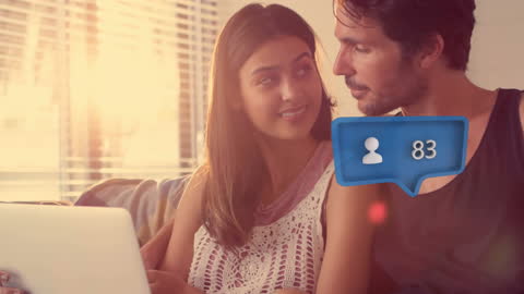 Couple Relaxing on Couch with Digital Social Icons Overlay