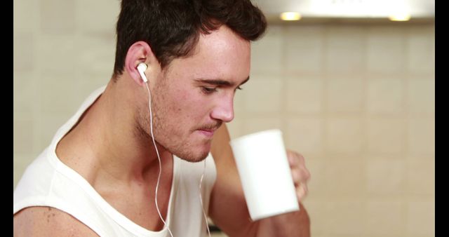 Young Man Drinking Coffee and Listening to Music with Earphones - Download Free Stock Images Pikwizard.com